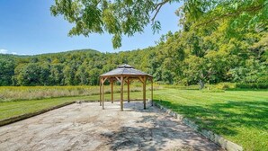 A gazebo with a stone floor and a grassy area with trees in the background. - 1800s Carriage house in Berkshires / Hudson Valley (New Lebanon)