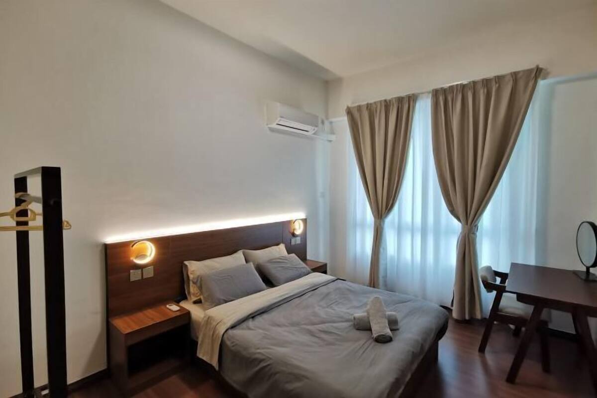 Una habitación de hotel con cama, mesita de noche y escritorio con silla.