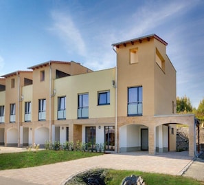 A multi-story residential building with a flat roof, large windows, and a central courtyard.