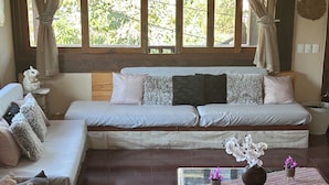 A living room with a sofa, a coffee table, and a window with curtains. - Sheiton Búzios (Búzios)