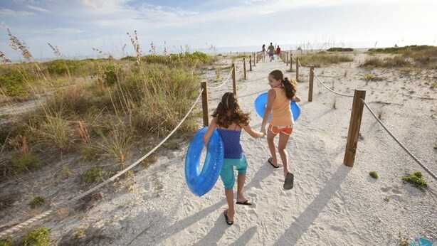 A sandy path with wooden posts and ropes, leading to a beach. - Charming 2b-2b condo in beautiful Fort Myers Beach- 10 min walk to the beach .  (Fort Myers Beach)