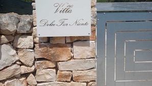 Eine Steinsäule mit einem Schild, auf dem 'Villa Dolce Far Niente' steht.