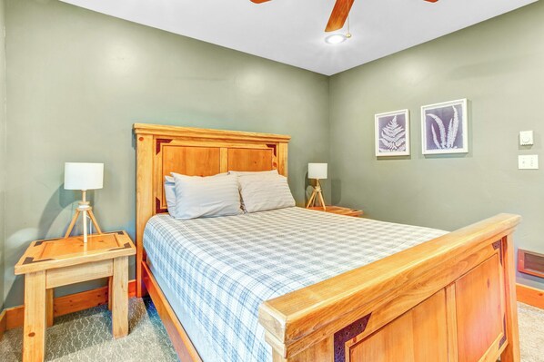 A bedroom with a wooden bed, two bedside tables with lamps, and two framed botanical prints on the wall. - Salida Cabin Rentals Close to Monarch Mountain and Hot Springs (Salida)