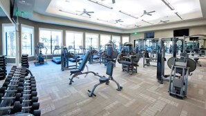 A spacious gym with various exercise equipment, large windows, and ceiling fans. - Gated area, Golfing, HOA Pool, Pickleball Courts, and Family Fun (Ave Maria)