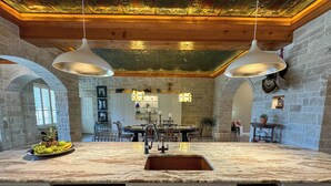 A kitchen with a marble countertop, stainless steel appliances, and a stone wall backdrop. - Bliss On The River (Llano)