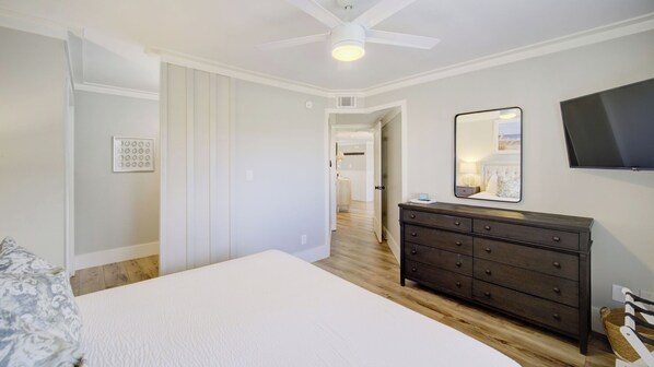A bedroom with a bed, dresser, mirror, and TV. - Triton Balcony w/ Pool View, Chic Design (Santa Rosa Beach)