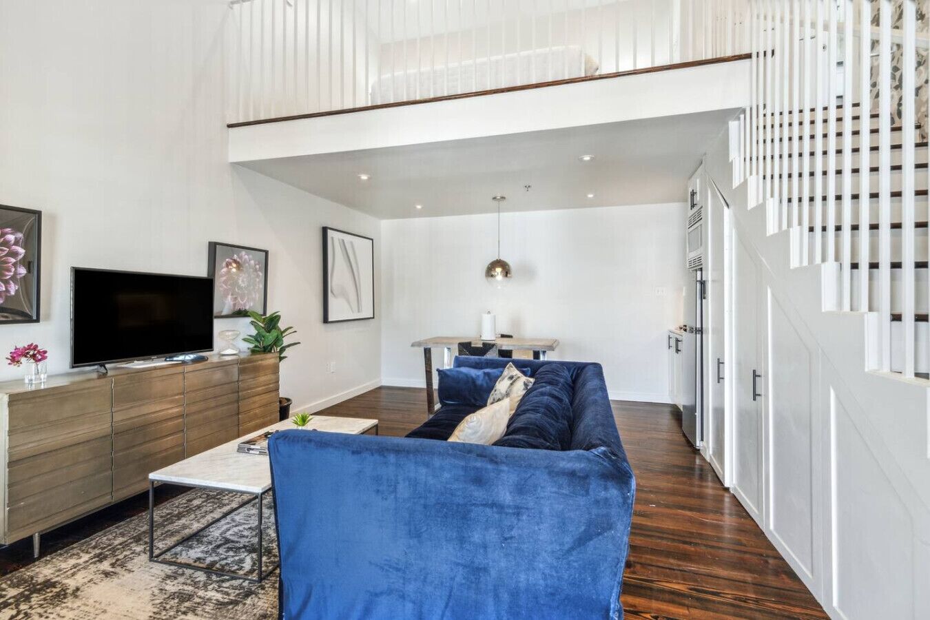 Un salon moderne avec un canapé bleu, un téléviseur à écran plat et un meuble en bois.