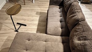 A sectional sofa with a wooden coffee table and a small side table. - Cozy studio in charming Santa Fe (Santa Fe)