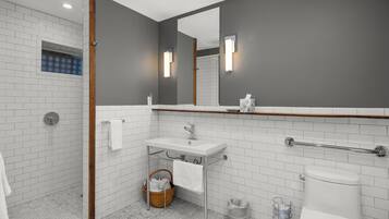 A modern bathroom with a white sink, a mirror, and a toilet.