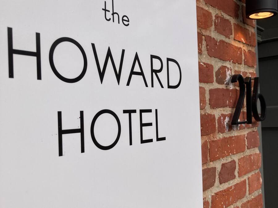 Een bord voor 'The Howard Hotel', met een bakstenen muur op de achtergrond en het nummer '216' rechts.