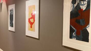 A hallway with three framed artworks on the wall.