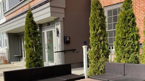 En utomhusplats med sittmöbler, ett bord i sten och möbler av rotting.