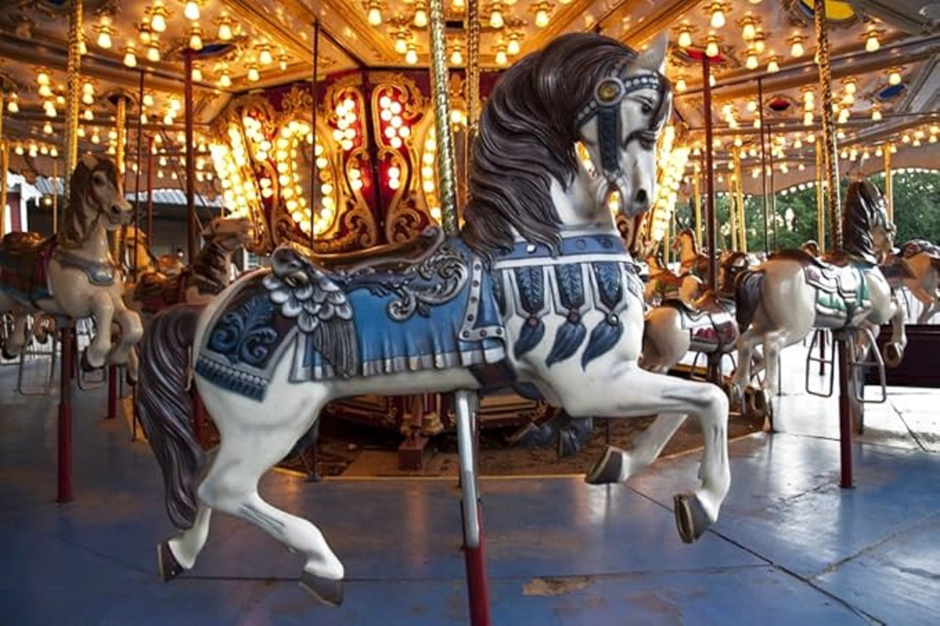 A carousel with ornate horses and lights.