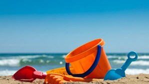 A beach scene with a sand bucket and shovel.