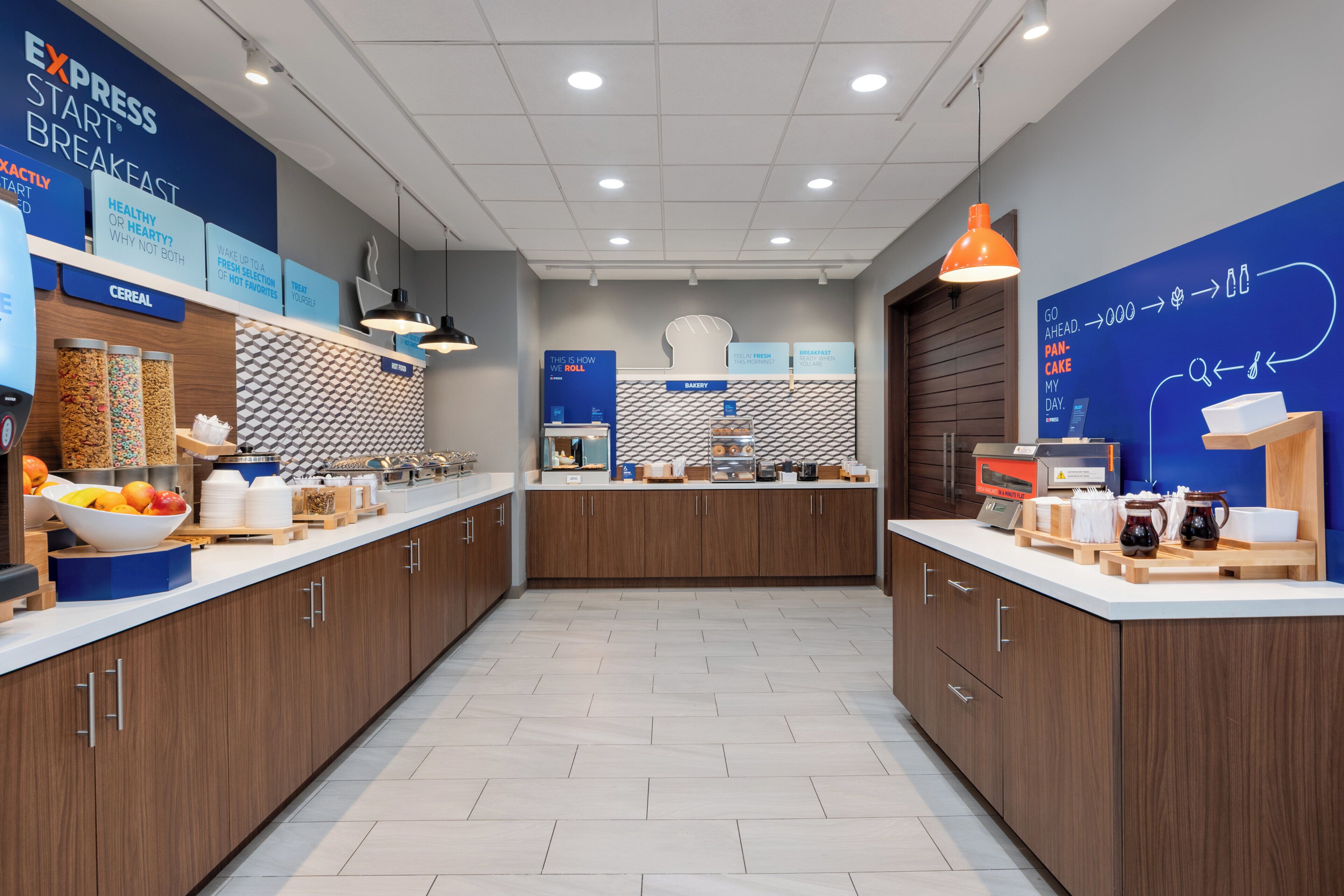 A modern breakfast area with wooden cabinets, a white countertop, and various breakfast items.