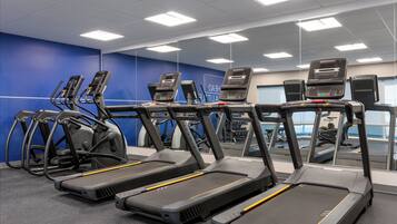 A gym with treadmills and elliptical machines.