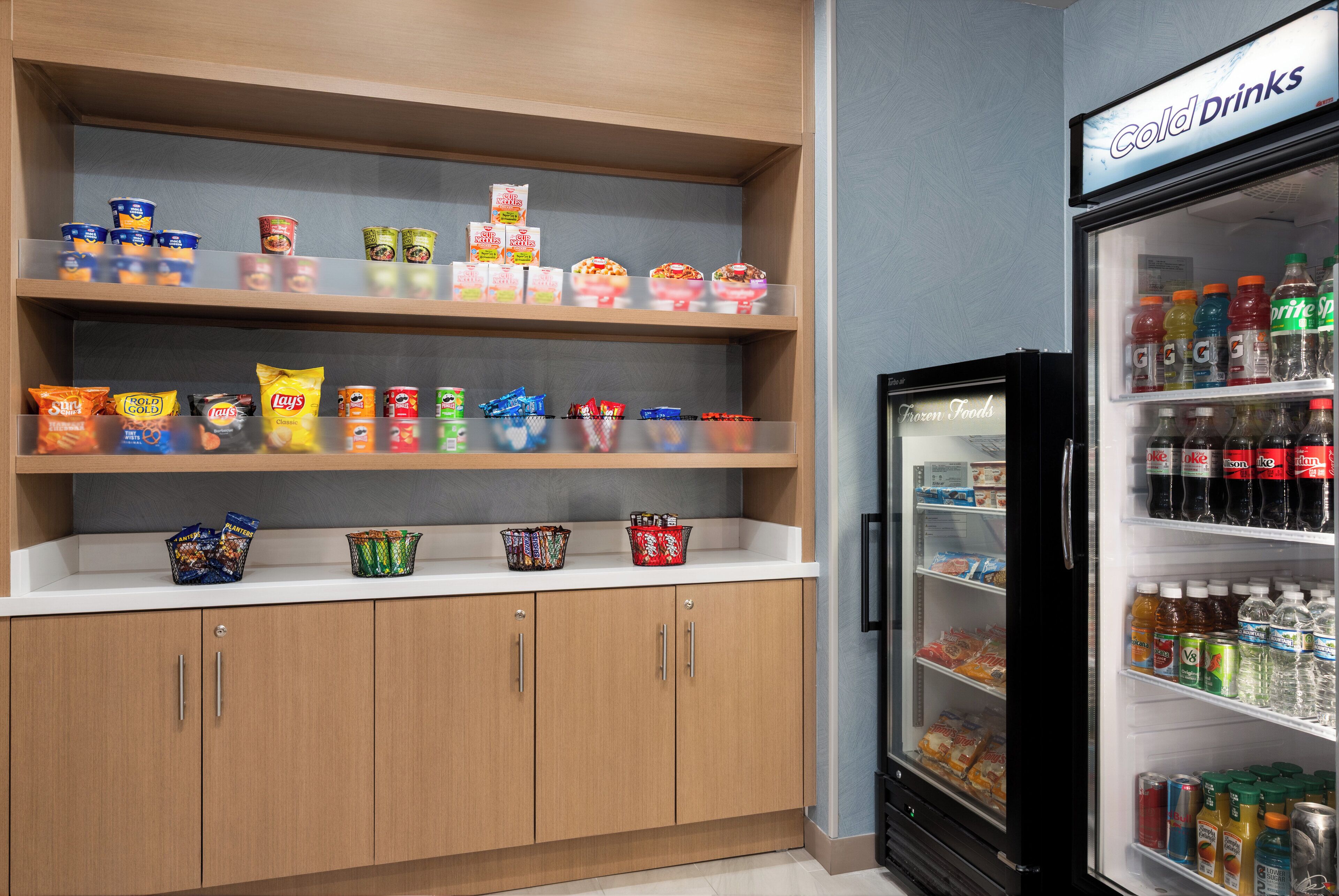 Een gekoelde vitrine met verschillende drankjes en snacks.