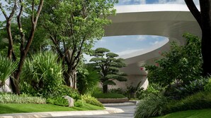 A pathway leading to a modern building with a curved roof, surrounded by lush greenery and trees. - Kimpton Aqeos Hainan by IHG (Lingshui)