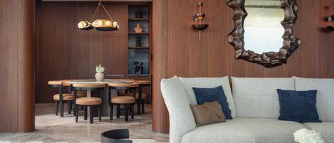Un salon moderne comprenant un canapé, une table basse et un coin repas avec des chaises et une table.