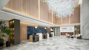 A modern lobby with a reception desk, seating area, and a fireplace. - Holiday Inn Express Nanchang High Tech Zone by IHG (Nanchang)