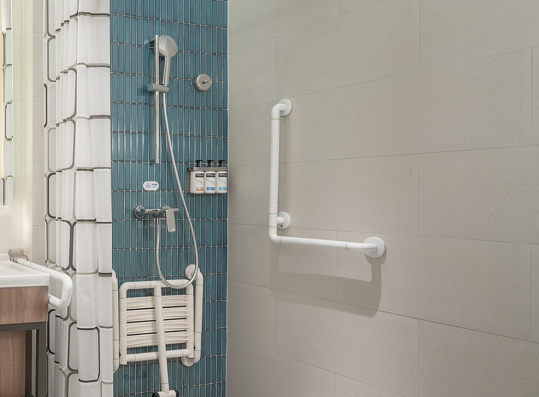 A bathroom with a shower, a towel rack, and a hand dryer.
