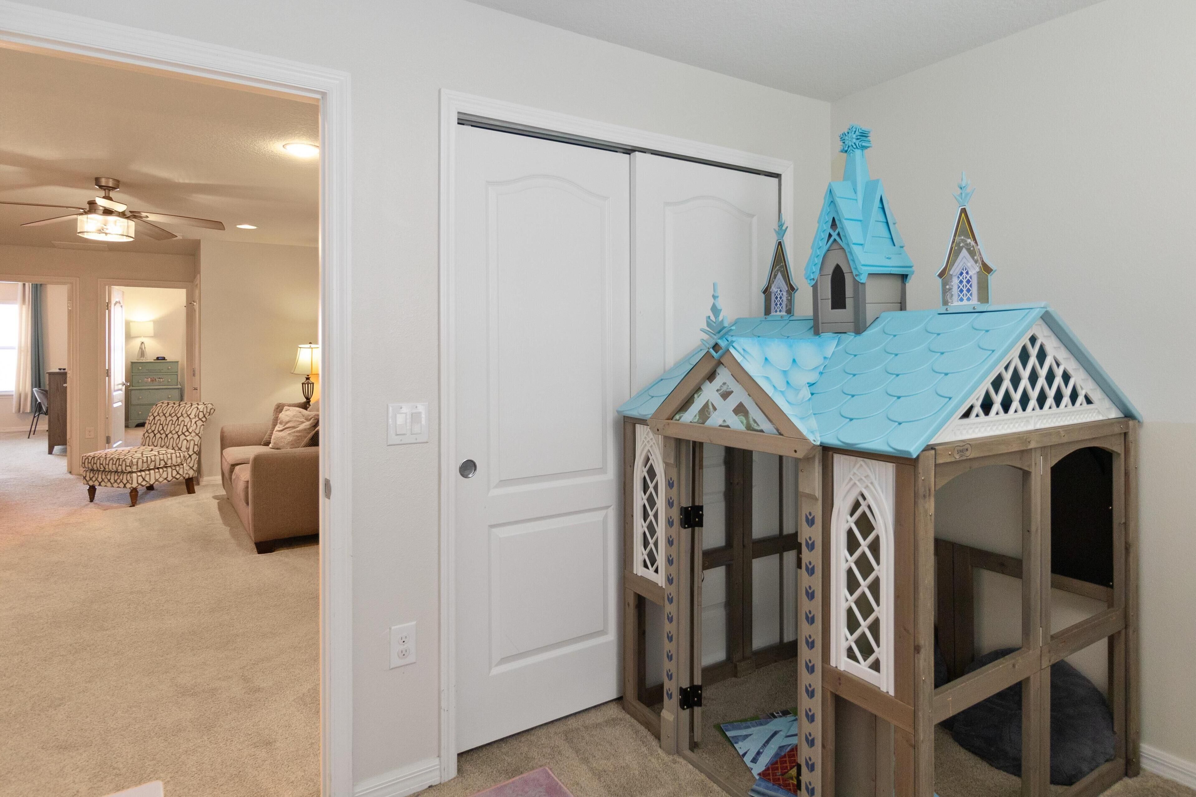 A playhouse with a blue roof and white lattice detailing.