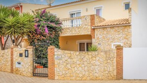 Una villa con muro de piedra, un portón y una antena parabólica.