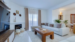 Una sala de estar moderna con chimenea, sofá, mesa de centro y televisor.