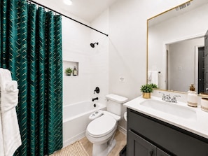 Un baño con bañera, inodoro y lavamanos.