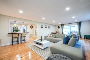 Un salon moderne avec un canapé, une table basse et un coin repas avec des chaises.