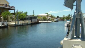 A calm waterway with buildings on the left and a dock with boats on the right. - 4-bedroom Waterfront Home in Key Largo with Dock (Key Largo)