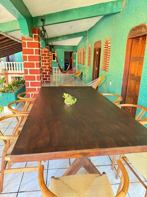 Un comedor amplio con una mesa de madera grande, rodeado de sillas de mimbre.