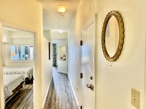 A hotel corridor with a bed, a mirror, and a door. - Tropical Resort, Beachfront Condo with amazing oceanfront views!! 322 (North Myrtle Beach)
