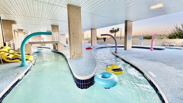 En indendørs swimmingpool med flere baner, et overdækket område og oppustelige flyderinge.