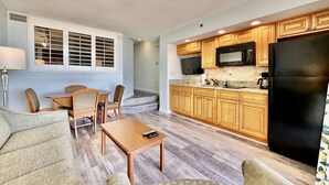 A compact living space with a dining area, kitchen, and seating. - Tropical Resort, Beachfront Condo with amazing oceanfront views!! 609 (North Myrtle Beach)