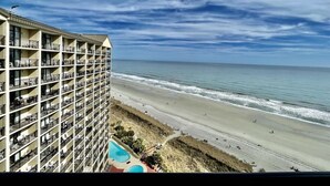 Um hotel com várias varandas com vista para uma praia e oceano.