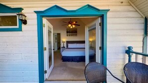 A bedroom with a bed, a ceiling fan, and a nightstand. - The Buttercup Cottage (San Marcos)
