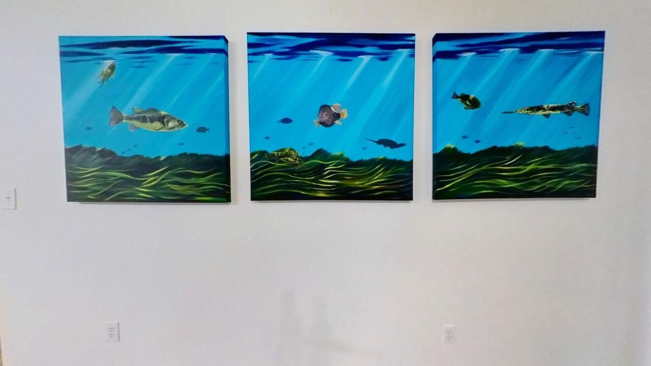 Tres cuadros subacuáticos en una pared.