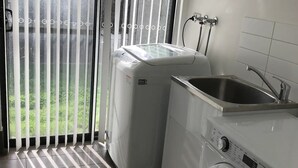 A laundry area with a washing machine, a dryer, and a sink.