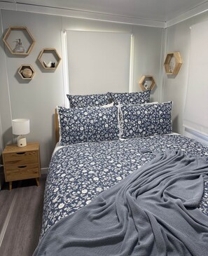 Une chambre à coucher avec un lit, une table de chevet et des étagères hexagonales en bois.