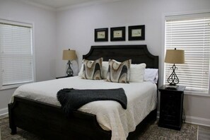 A bedroom with a large bed, two bedside tables with lamps, and three framed certificates on the wall. - Tanglewood Oxford Getaway (Oxford)
