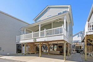 A two-story building with a balcony, wooden deck, and a sign indicating a restaurant.