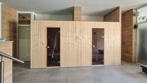 A modern kitchen with wooden paneling, a tiled floor, and a visible stove. - Stunning apartment in Insko with sauna (Insko)