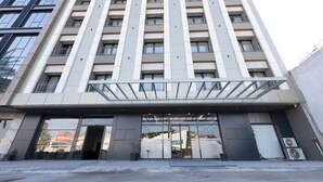 A multi-story hotel with a modern facade, large windows, and a prominent entrance. - Restway Hotel (Izmir)