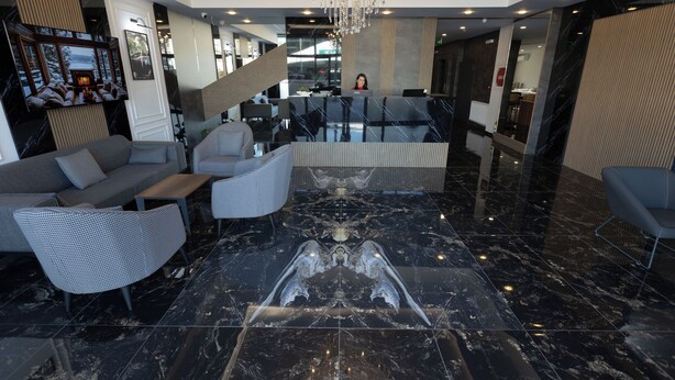 A modern lobby with a reception desk, seating area, and a chandelier. - Restway Hotel (Izmir)