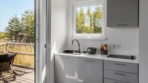 Cocina pequeña con ventana, un lavabo y una pequeña encimera.