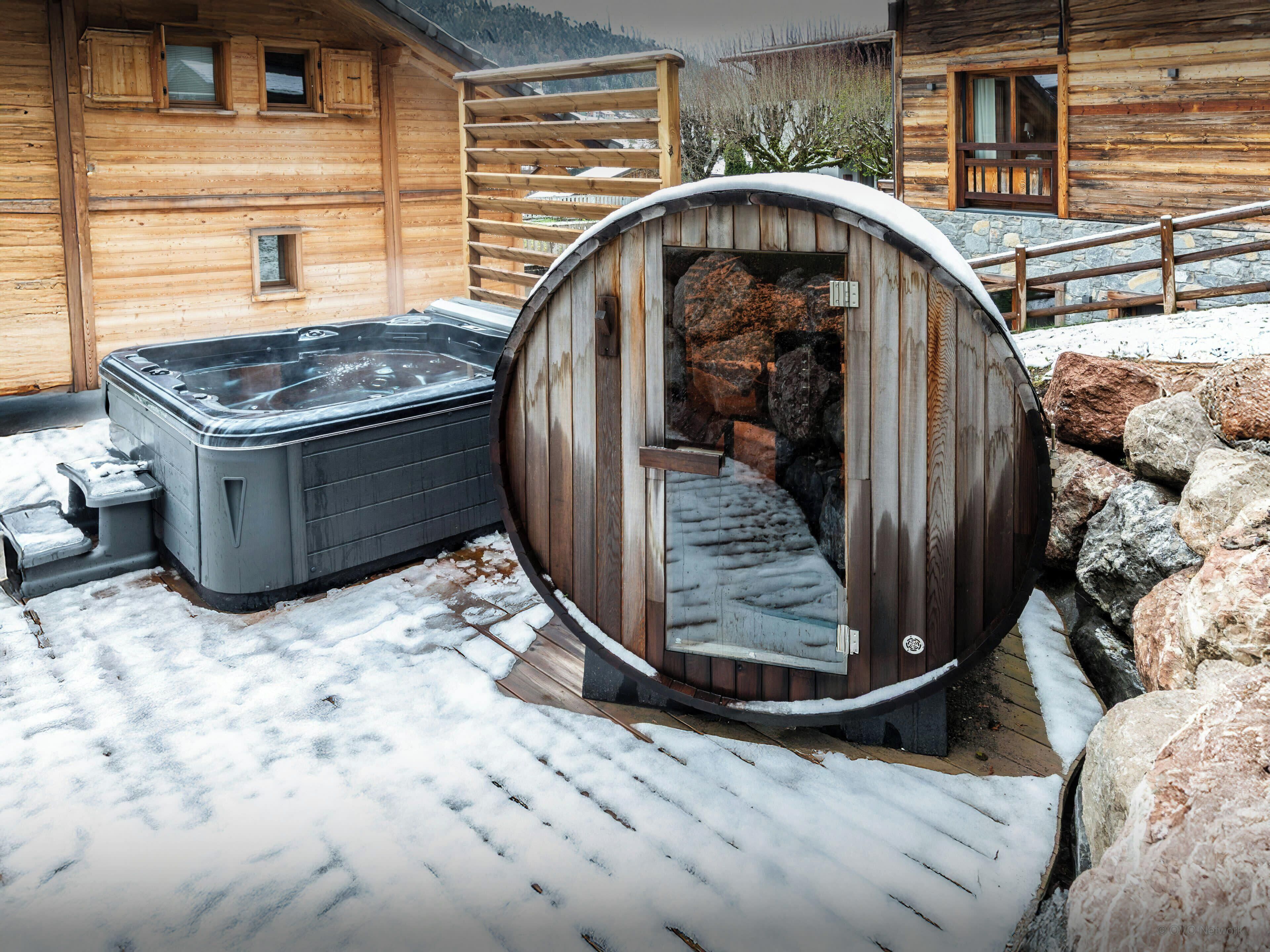 Una baita in legno con vasca idromassaggio e sauna.
