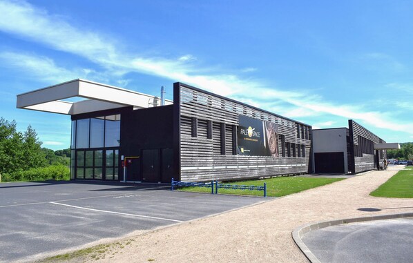 A modern building with large windows, a covered entrance, and a sign reading "PALE SPACE".