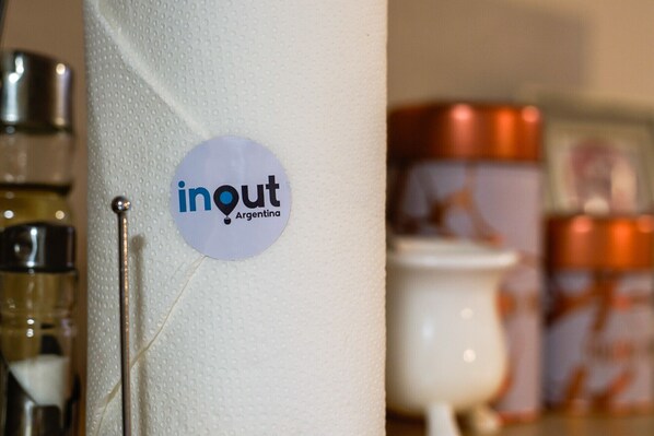 En vit pelare med en logotyp som visar texten ”inout Argentina”, och en metallstång som är fäst vid den.