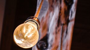 A string of vintage-style light bulbs hanging from a wooden beam.